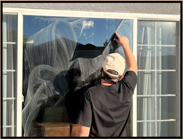 Worker washing house windows